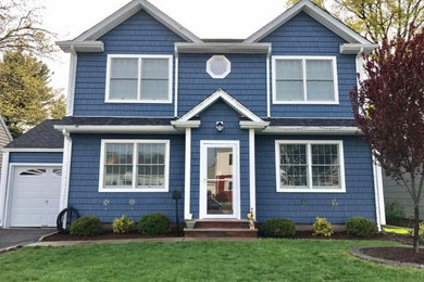Medium sized and blue traditional two floor detached house in New York with wood cladding, a pitched roof and a shingle roof.