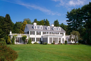 Large elegant white two-story vinyl exterior home photo in Boston with a shingle roof