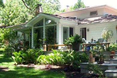 Diseño de fachada blanca de estilo de casa de campo de tamaño medio de dos plantas con revestimiento de vinilo y tejado a dos aguas