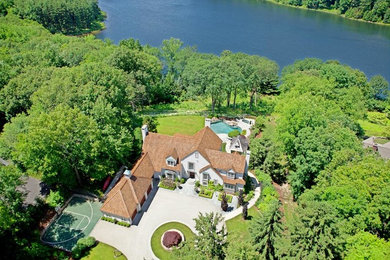 Elegant beige three-story stucco house exterior photo in New York with a shingle roof