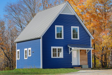 Country blue two-story metal exterior home idea in Boston with a metal roof