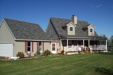 Réalisation d'une grande façade de maison beige tradition en bois à un étage avec un toit à deux pans et un toit en shingle.