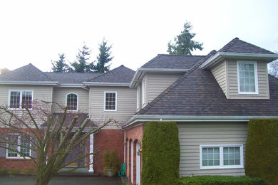 Ejemplo de fachada de casa beige tradicional grande de dos plantas con tejado a cuatro aguas y tejado de teja de madera