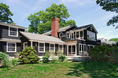 Imagen de fachada de casa marrón tradicional grande de dos plantas con revestimiento de madera, tejado a cuatro aguas y tejado de teja de madera