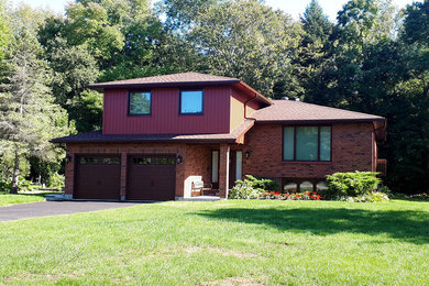 Example of a mid-sized classic red split-level mixed siding house exterior design in Toronto with a hip roof and a shingle roof