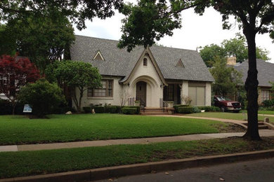 This is an example of a medium sized and white classic bungalow brick house exterior in Dallas with a pitched roof.