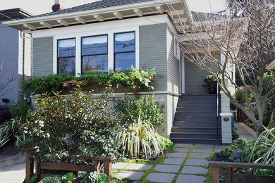 Example of a mid-sized transitional green two-story wood house exterior design in San Francisco with a hip roof and a shingle roof
