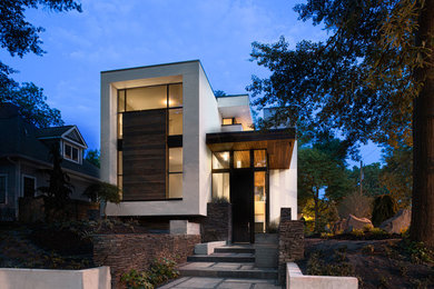 Aménagement d'une façade de maison métallique et blanche moderne de taille moyenne et à un étage.