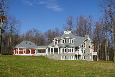 Imagen de fachada roja contemporánea extra grande de tres plantas con revestimiento de piedra y tejado a cuatro aguas