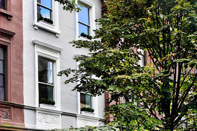 Example of a huge classic gray three-story exterior home design in New York