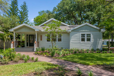 Inspiration for a large timeless green one-story concrete fiberboard exterior home remodel in Tampa with a shingle roof