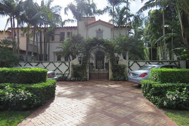 Mid-sized tuscan red two-story stucco house exterior photo in Miami with a tile roof