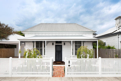 Modelo de fachada de casa blanca clásica de tamaño medio de una planta con revestimiento de madera, tejado a cuatro aguas y tejado de metal