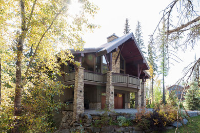 Example of a large mountain style green three-story wood gable roof design in Calgary