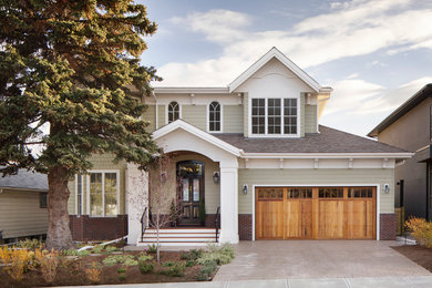 Inspiration for a large timeless green two-story concrete fiberboard exterior home remodel in Calgary with a shingle roof