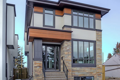 Example of a classic two-story stucco house exterior design in Calgary