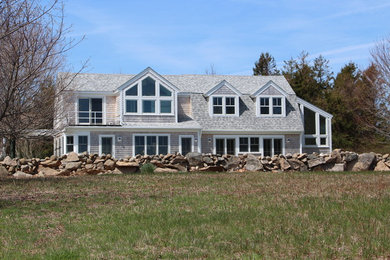 Cette photo montre une façade de maison grise chic en bois de taille moyenne et à un étage avec un toit de Gambrel.