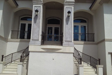 Ejemplo de fachada de casa beige grande de tres plantas con revestimiento de estuco y tejado a dos aguas