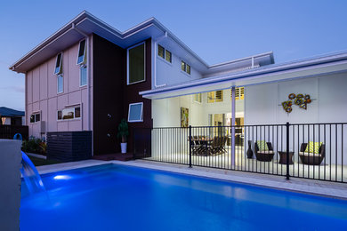 Diseño de fachada de casa multicolor minimalista grande de dos plantas con revestimientos combinados, tejado a cuatro aguas y tejado de metal