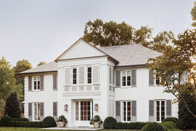 Large elegant white two-story brick exterior home photo in Charlotte