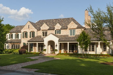 Cette image montre une grande façade de maison blanche traditionnelle à un étage avec un revêtement mixte et un toit à quatre pans.