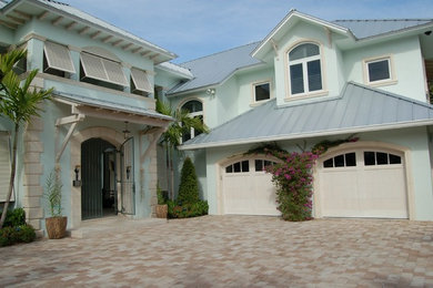 Example of an island style blue two-story exterior home design in Miami