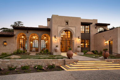 Inspiration for a large mediterranean beige three-story house exterior remodel in Santa Barbara with a shed roof and a tile roof