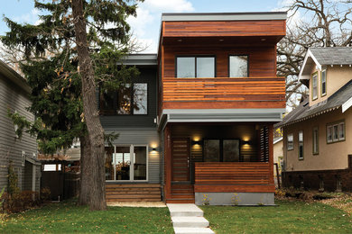 Modelo de fachada de casa contemporánea de tamaño medio de dos plantas con revestimiento de madera y tejado plano