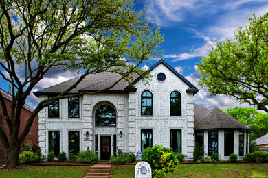 Inspiration for a transitional white two-story brick house exterior remodel in Dallas with a shingle roof