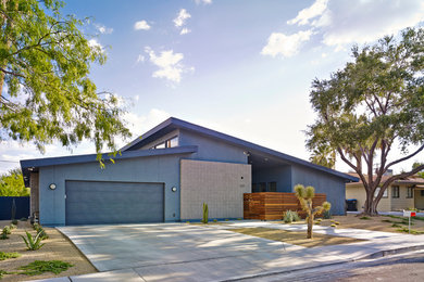 Imagen de fachada azul vintage de tamaño medio de una planta con revestimiento de estuco y tejado de un solo tendido