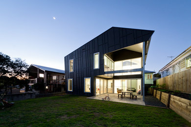 На фото: двухэтажный, черный дом среднего размера в современном стиле с облицовкой из ЦСП и плоской крышей
