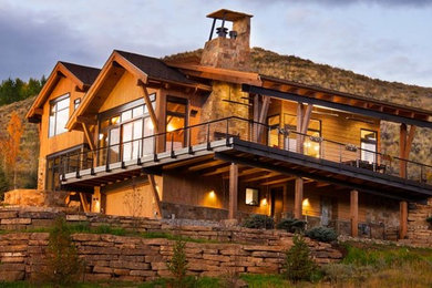 Design ideas for a rustic split-level house exterior in Denver with wood cladding.