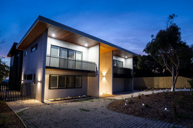 Diseño de fachada de casa minimalista de dos plantas con revestimiento de aglomerado de cemento