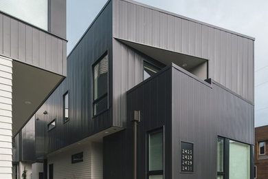 Imagen de fachada de casa bifamiliar gris moderna de dos plantas con revestimiento de metal