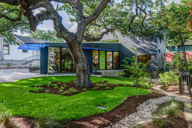 На фото: серый, маленький, двухэтажный дом в современном стиле с плоской крышей для на участке и в саду с