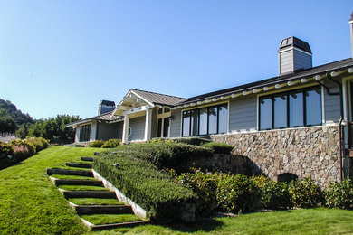 Medium sized and gey classic bungalow detached house in San Francisco with wood cladding, a hip roof and a metal roof.