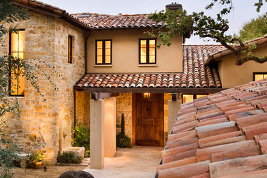 Ispirazione per la facciata di una casa grande beige mediterranea a due piani con rivestimento in pietra