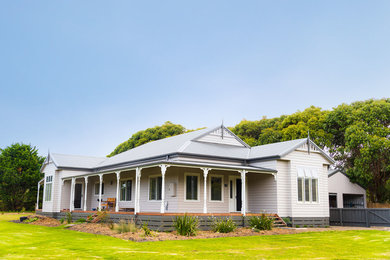 Imagen de fachada de casa gris campestre grande de una planta con tejado a dos aguas y tejado de metal