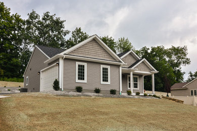 Cette image montre une petite façade de maison grise traditionnelle de plain-pied avec un revêtement en vinyle.