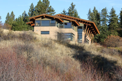 Imagen de fachada de casa gris contemporánea grande de dos plantas con revestimiento de hormigón, tejado a dos aguas y tejado de metal