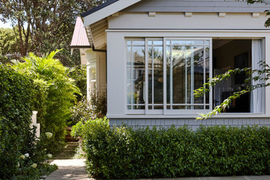 Modelo de fachada de casa gris tradicional grande de dos plantas con revestimiento de madera y tejado de metal