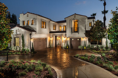 Large tuscan white two-story stucco exterior home photo in Los Angeles