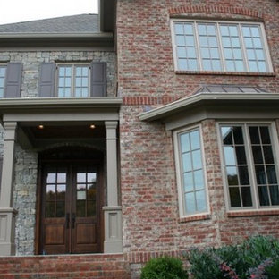 Inspiration for a large gray two-story stone gable roof remodel in Nashville