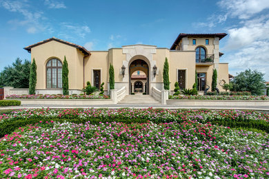 Example of a tuscan beige two-story stucco house exterior design with a tile roof