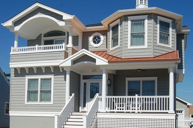 Example of a large beach style green two-story exterior home design in Philadelphia