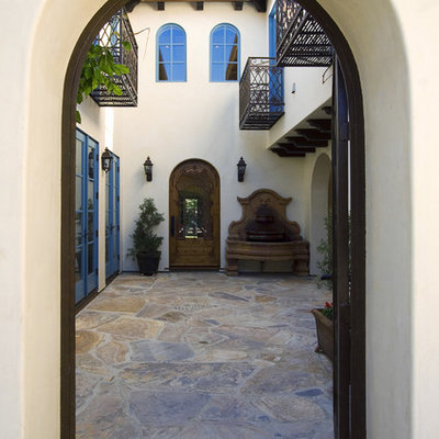 Mid-sized tuscan beige two-story stucco exterior home photo in Los Angeles
