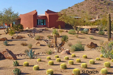 Example of a small trendy orange two-story stucco exterior home design in Phoenix with a green roof