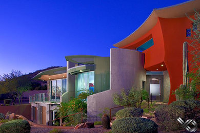 Photo of a medium sized modern two floor detached house in Phoenix with an orange house and a metal roof.