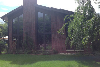 Imagen de fachada marrón minimalista de dos plantas con revestimiento de ladrillo