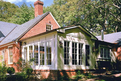 Imagen de fachada de casa beige tradicional de tamaño medio de una planta con revestimiento de ladrillo, tejado a dos aguas y tejado de teja de madera
